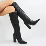 Black knee-high boots with high heels on a white background